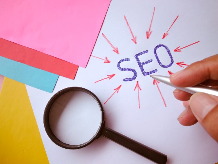 SEO geschrieben neben einer Lupe
